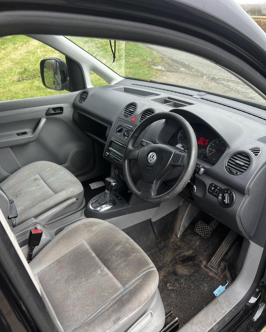 Caddy cab before: worn grey cloth seats and standard dashboard