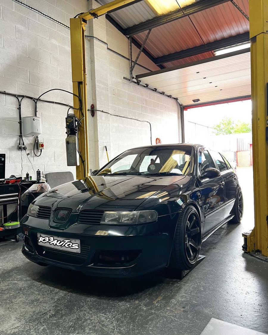Black SEAT Leon on the ramp in the workshop
